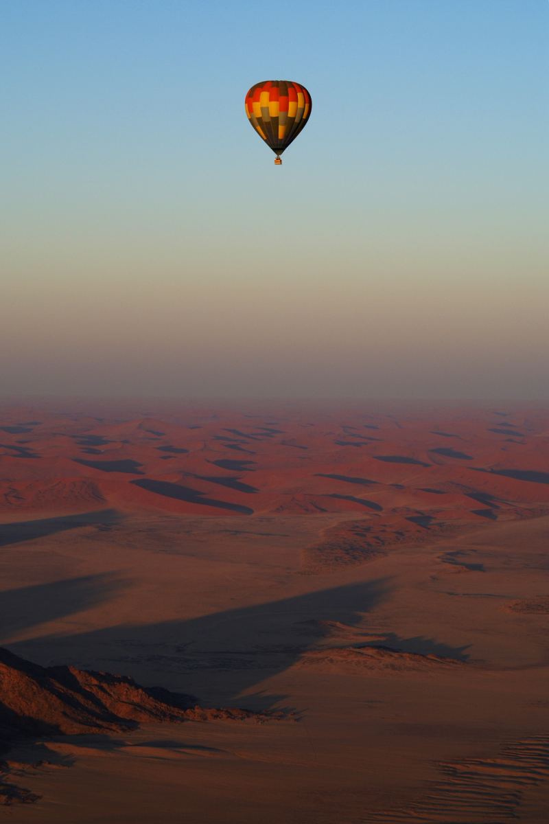 The view from a hot air balloon over dune fields in the morning haze